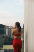 Racerback of the EQL x RAH sports bra in Lava with the RAH by Atilia mark